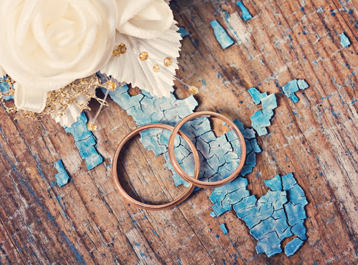 Wedding rings on grunge wooden background