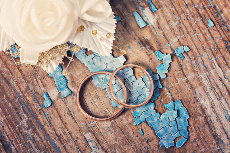 Wedding rings on grunge wooden background